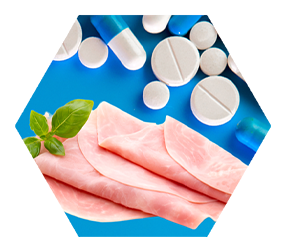 close up image of deli meat below blue and white pill capsules and tablets on blue background 