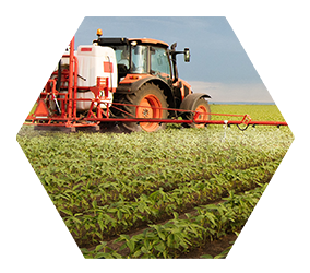 industrial farm tractor spraying pesticides on crops