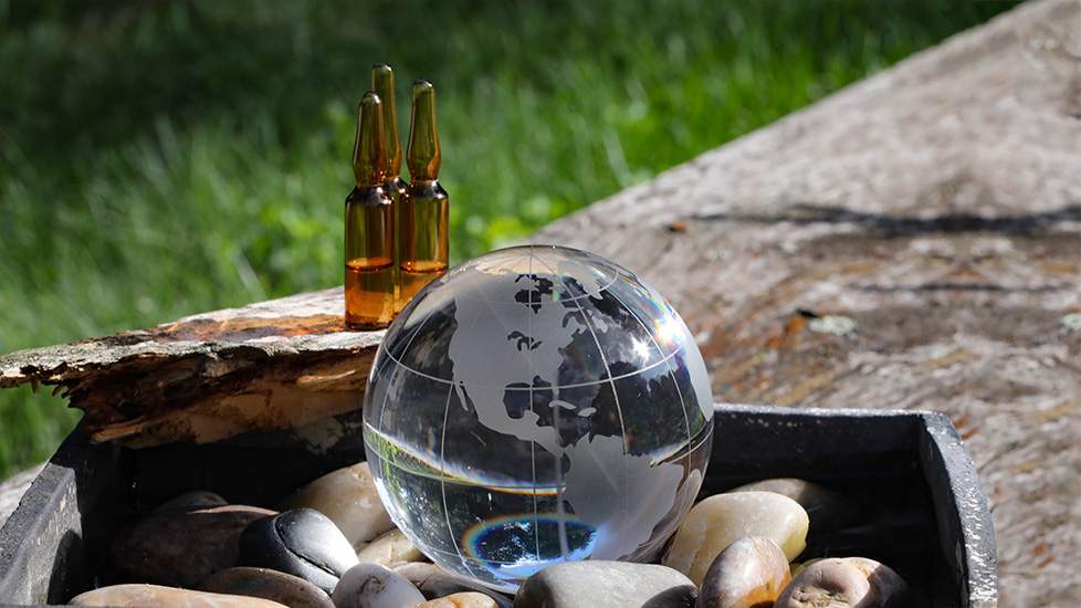 Small glass globe in rock garden outdoors in front of Chemical reference standards (ampule)